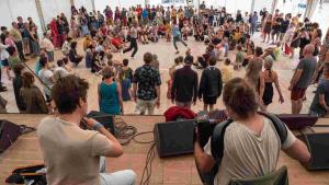 Musiker sehen vor der Bühne viele Menschen die zwei Tanzlehrern zuschauen